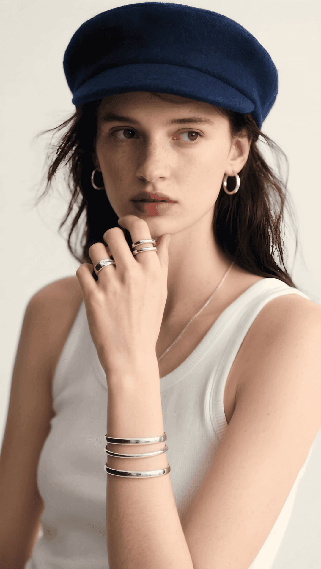 young woman in blue cap with jewelry