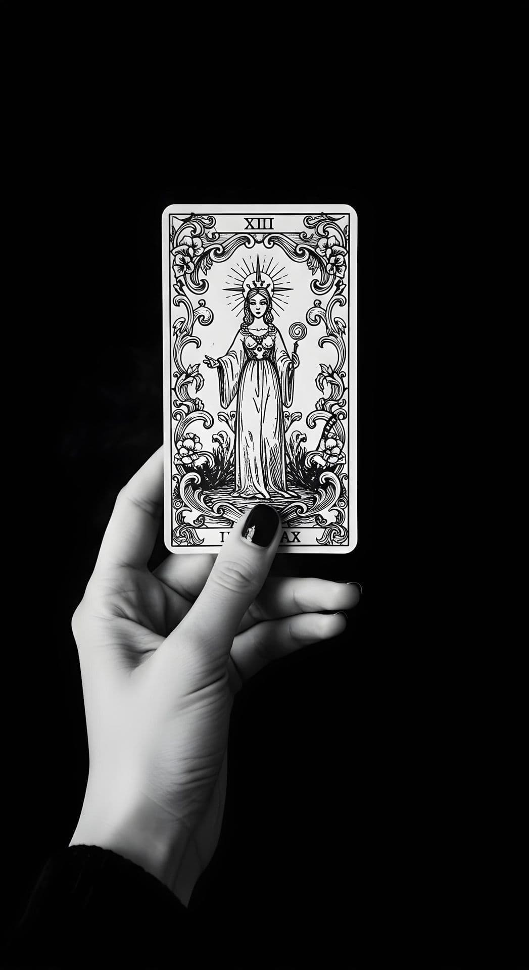 A hand with black-painted nails holds a tarot card against a black background.
