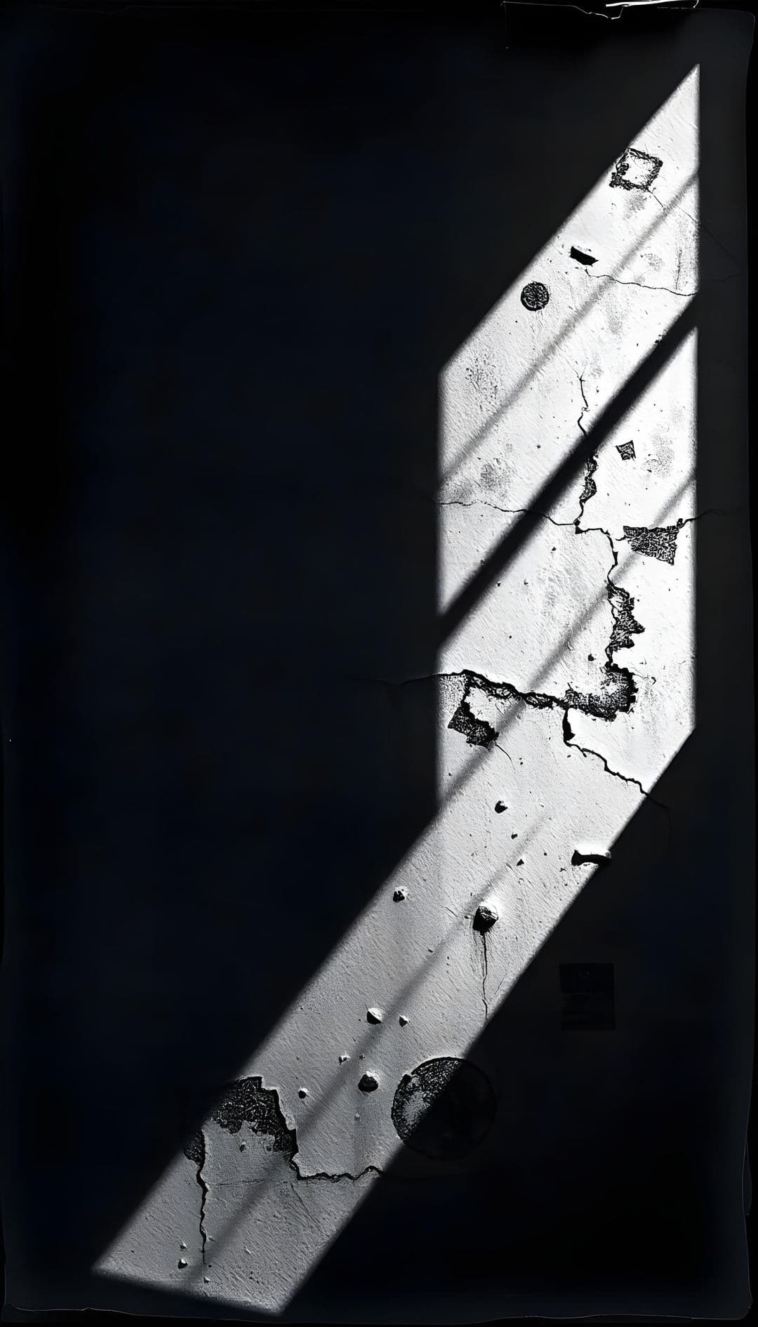 Moody interior with light and shadows on a cracked wall.