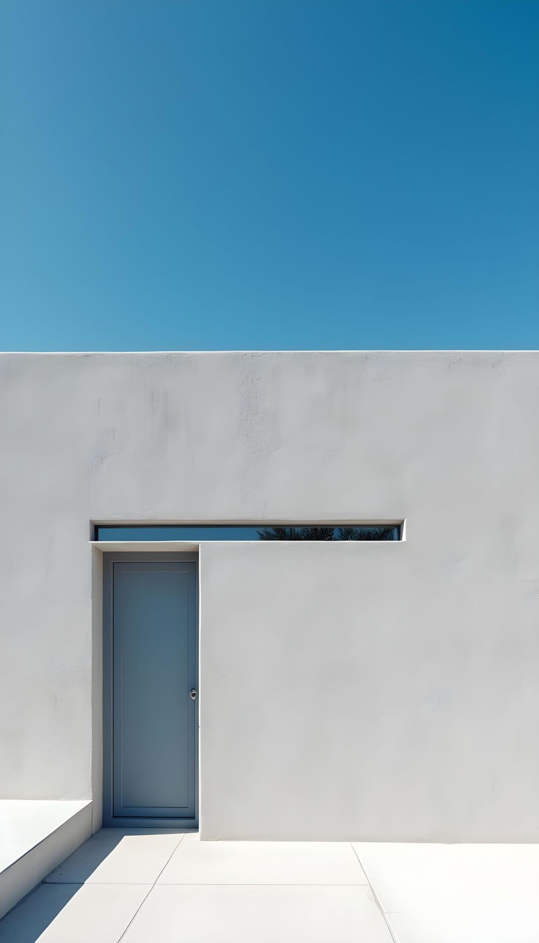 Flat white wall with doorway and window under blue sky