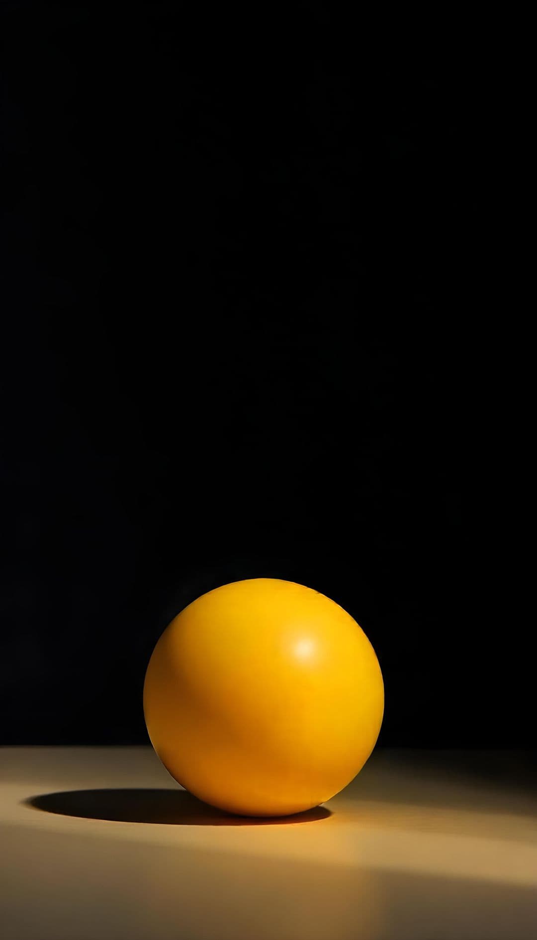 A bright yellow sphere on a dark background with dramatic lighting.